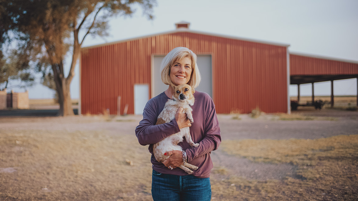 Jan Lawrence and her dog in front of one of their storage buildings.