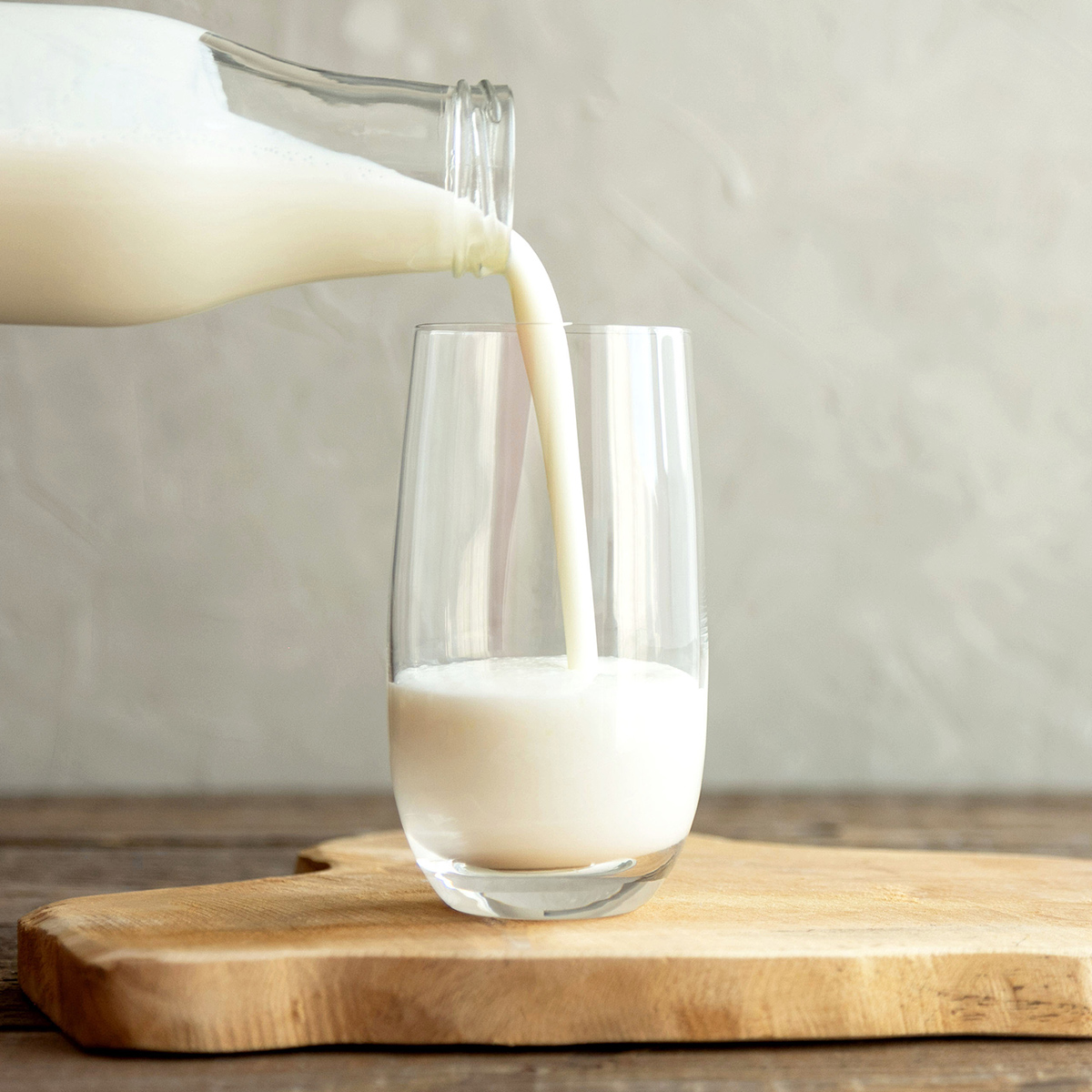 Glass of milk being poured from a bottle