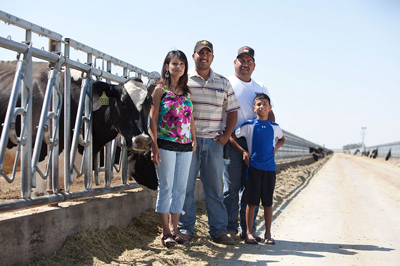 The family poses in front of their herd.